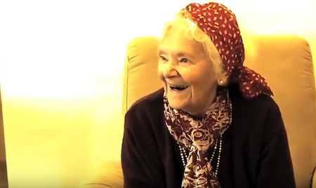 Lachende ältere Frau mit rotem Kopftuch