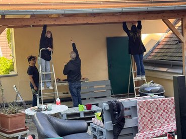 Mehrere Personen arbeiten an einer Holzpergola