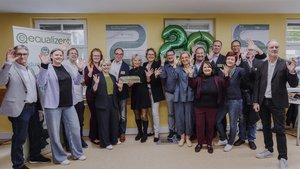 Eine gruppe von Personen, unter ihnen Fördergeber des equalizent, stehen im Halbkreis und schauen freundlich in die Kamera.