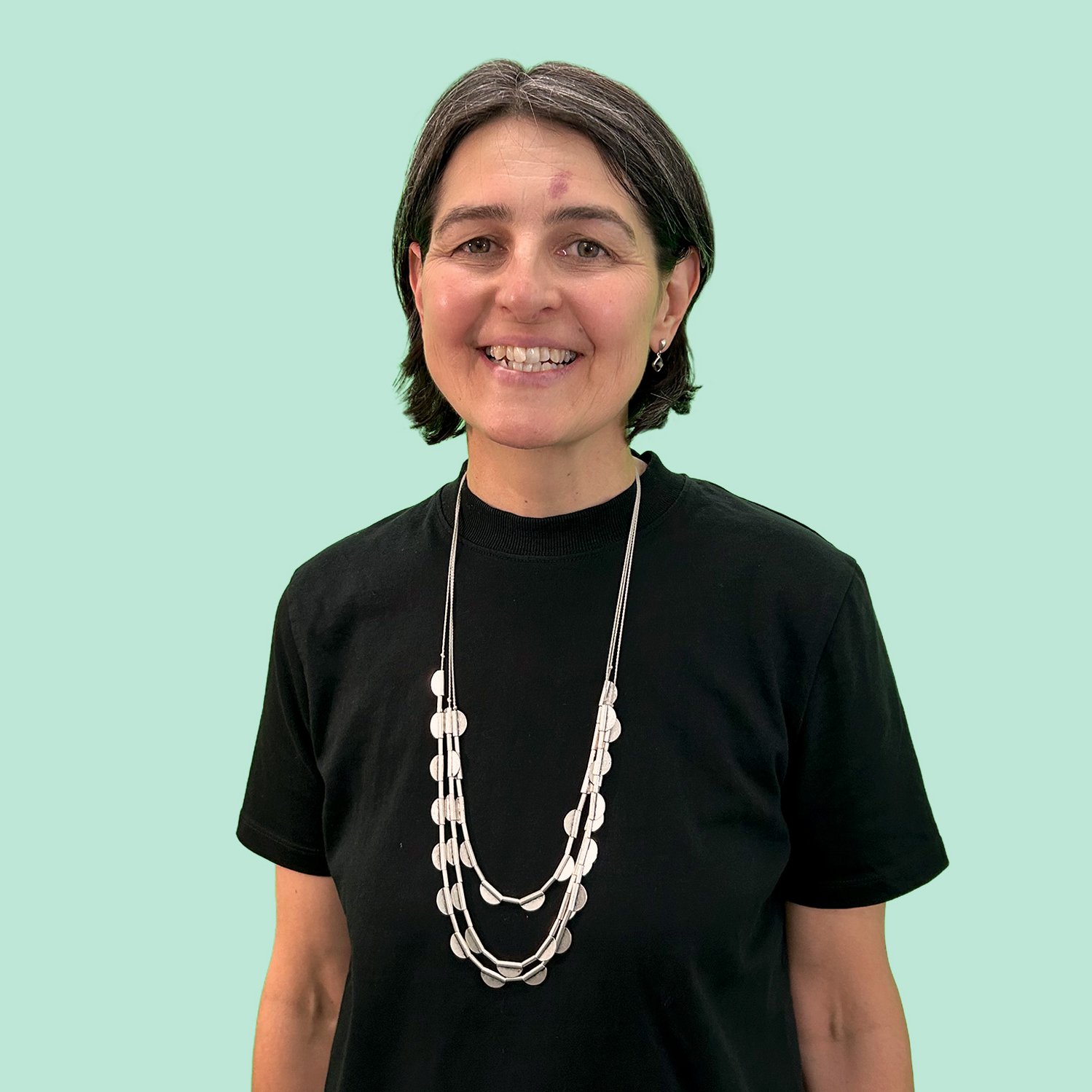 Marianne Schmidt vor türkisem Hintergrund