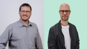 Zu sehen sind 2 Männer im Portraitformat. Links Matthias Fenkart in grauem Hemd mit Brille und kurzen dunkelblonden Haaren, freundlich lächelnd. Rechts Thorben Pachler mit offenem blauen Hemdn, darunter ein weißes T-Shirt. Er trägt eine Brille und einen kurzen Bart und hat eine Glatze.