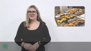 Frau mit langen Haaren und Brille trägt ein weißem T-Shirt. Neben ihr ist ein Foto von Weihnachtskeksen eingeblendet.