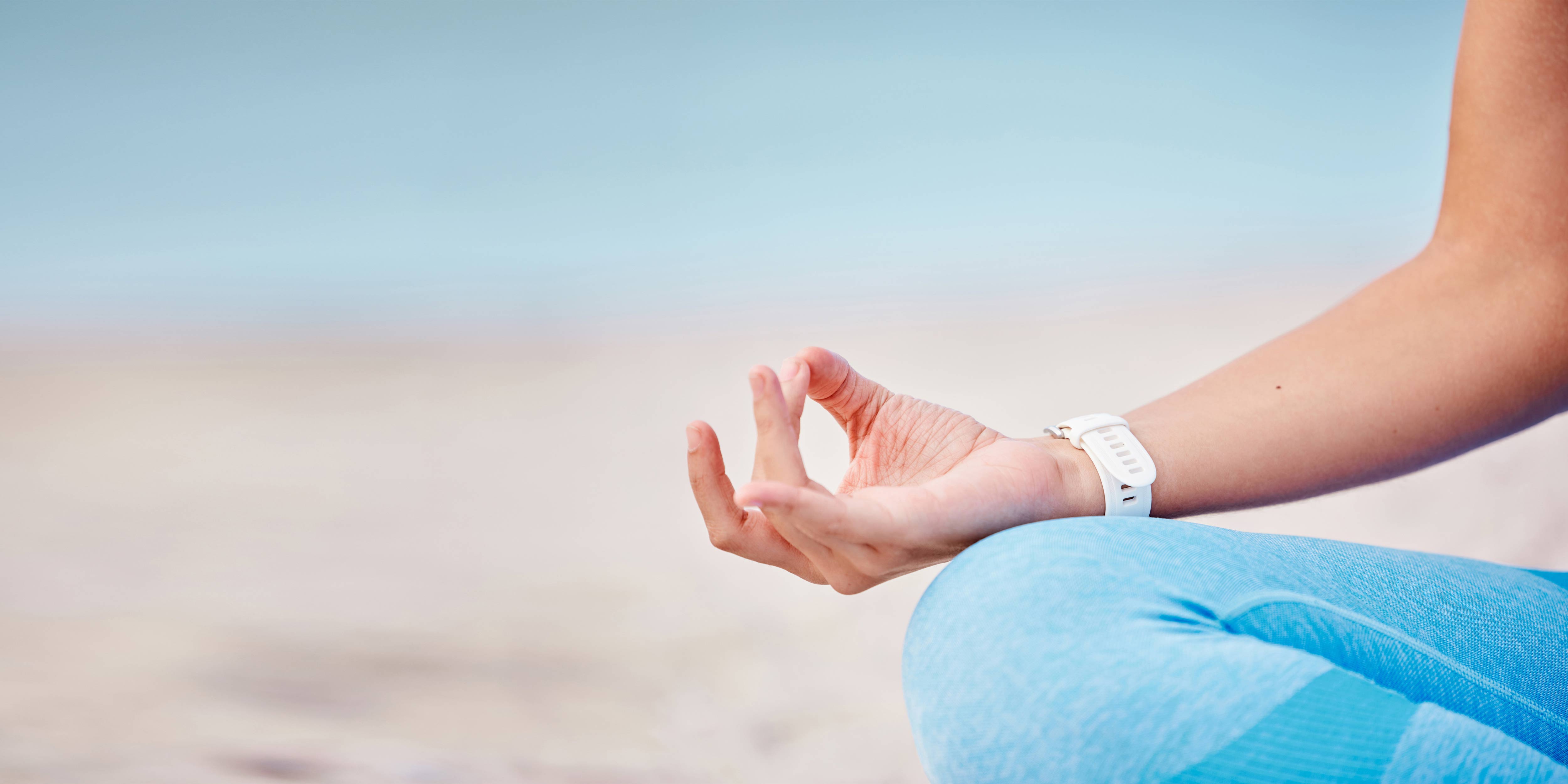 Ausschnitt eines Fotos. MAn sieht einen Teil einer Frau, die in Yoga-Position sitzt