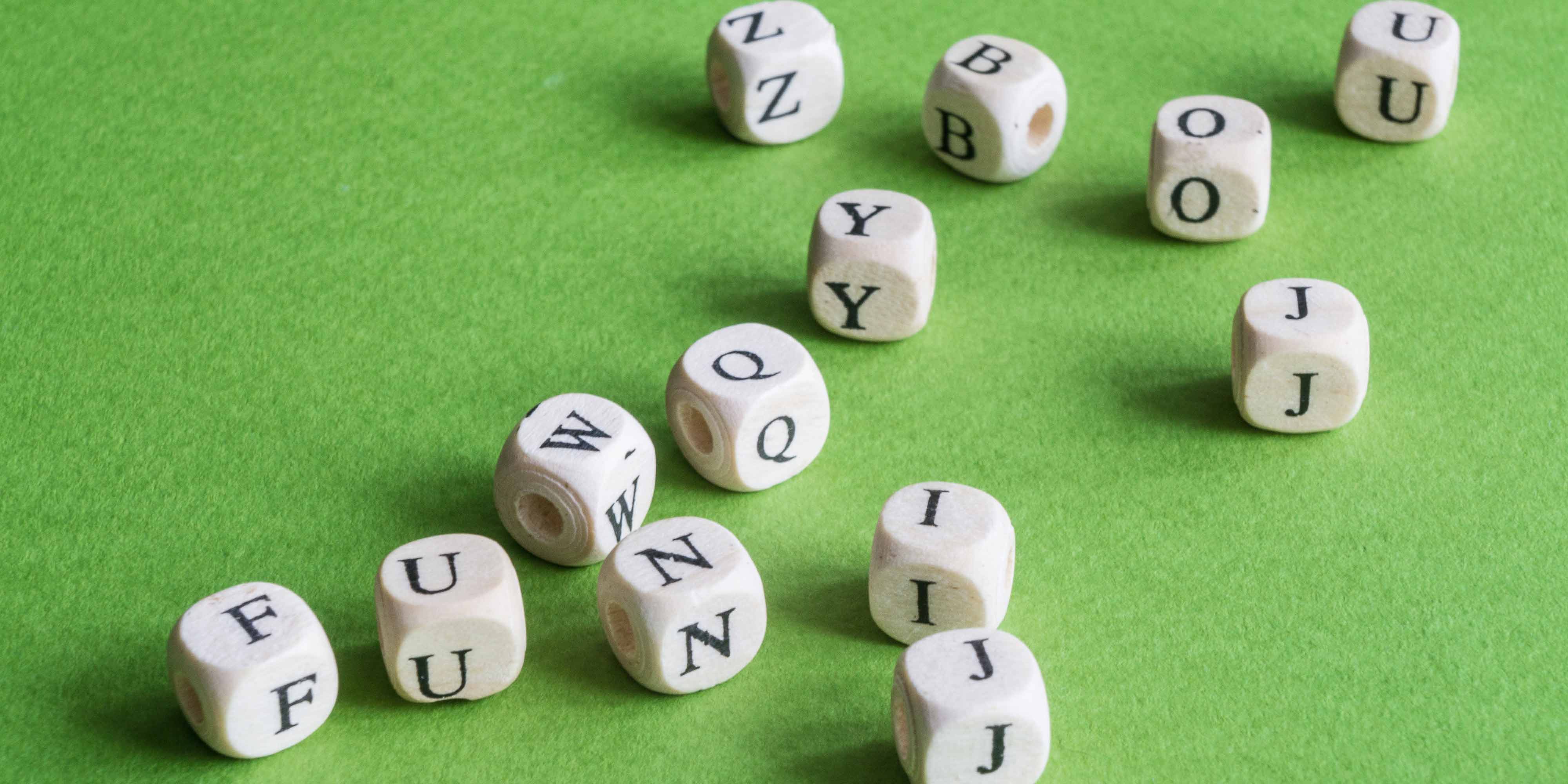 Würfel mit Buchstaben liegen auf grünem Untergrund