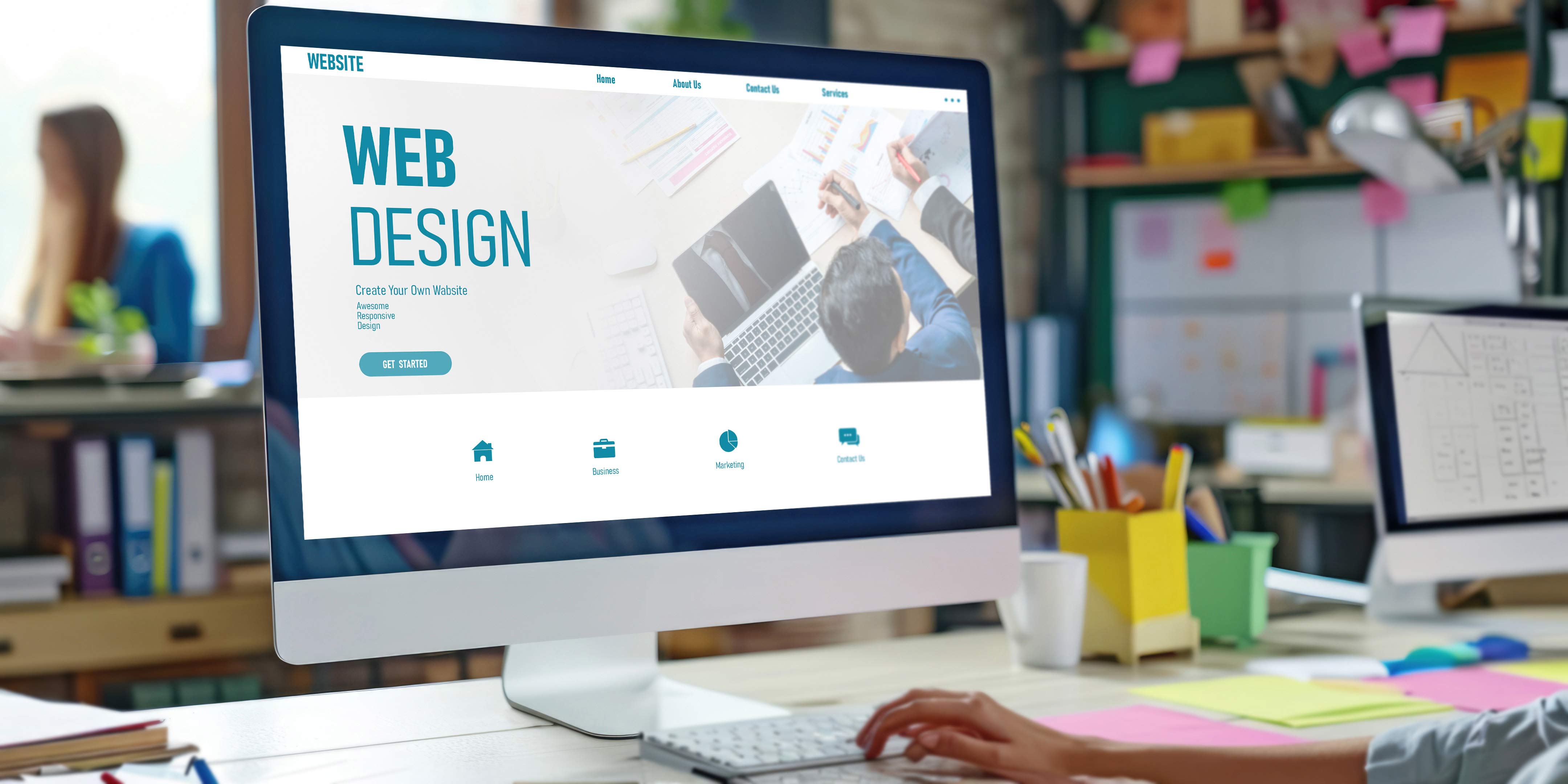 Compterbildschirm auf einem Schreibtisch. Auf dem Bildschirm steht geschrieben "Web design. Create your own website"